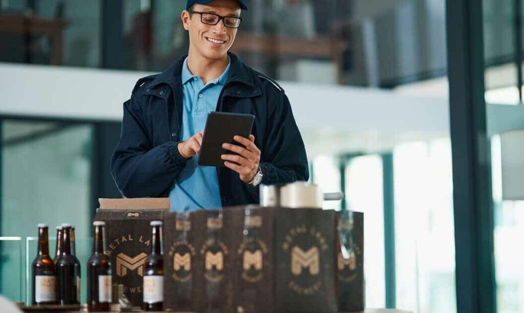 A brewery employee inspecting bottle of lager.