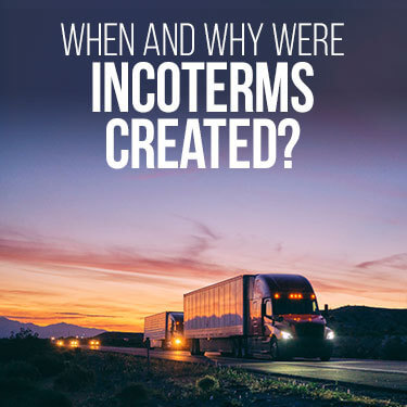 A semi truck going down a highway at night with other vehicles behind it