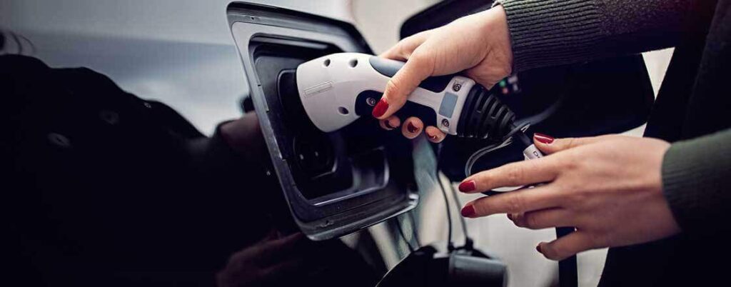 EV imports - An electric vehicle is hooked up to a charging station