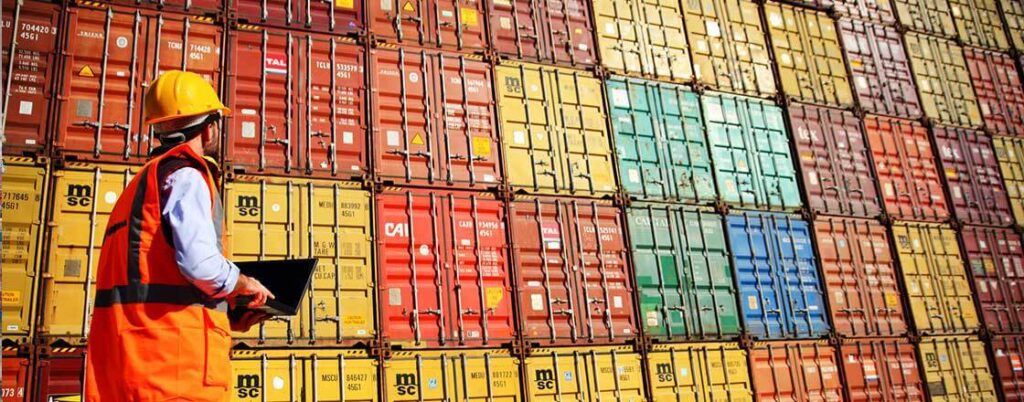inspector looking at a stack of shipping containers
