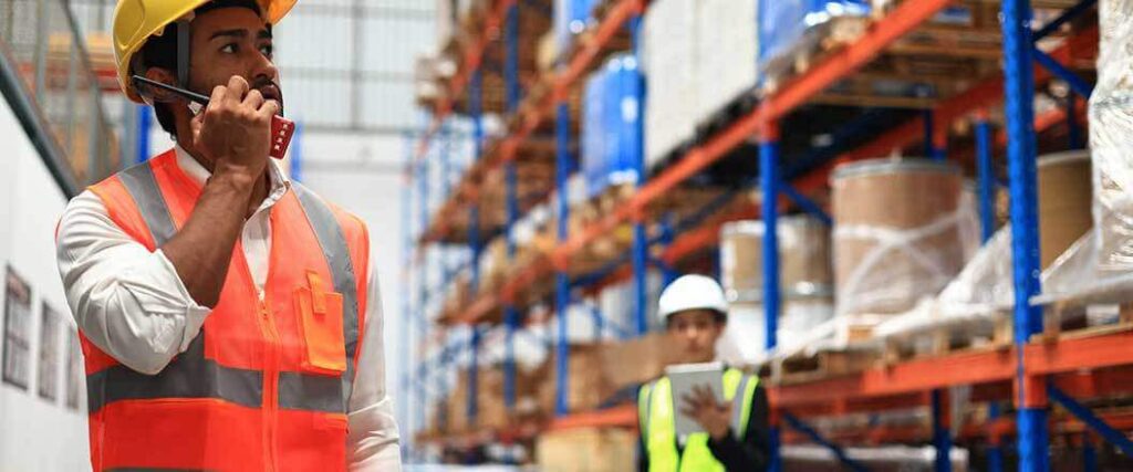 Warehouse workers speaking on a walkie talkie