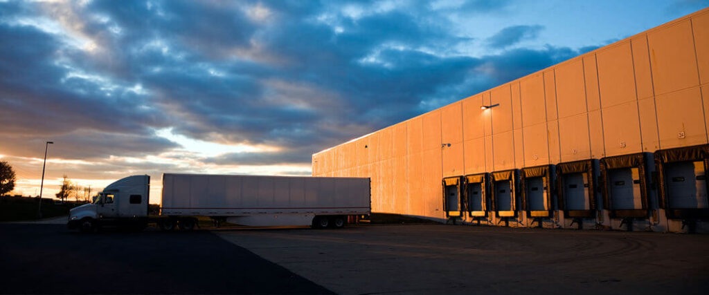 truck and trailer backed into waiting spot at a truck terminal.
