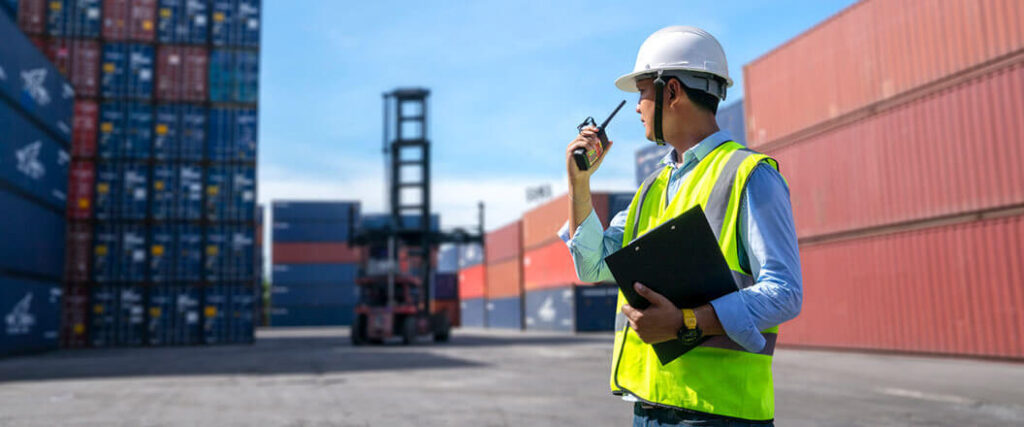 how to calculate countervailing duty as man speaks into a walkie talkie surrounded by shipping containers