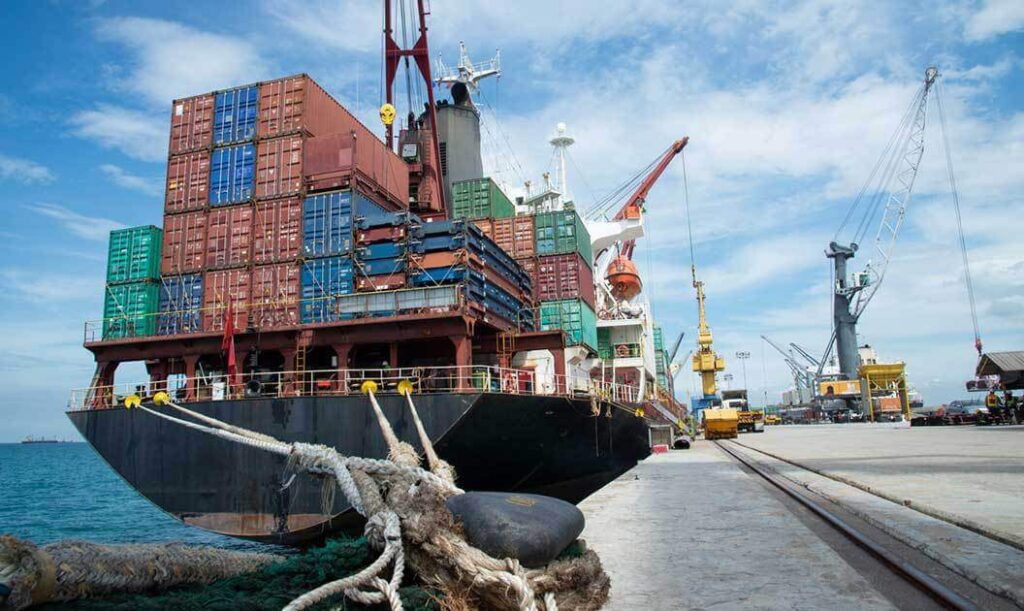 Ropes tied to a dock and and a cargo container ship