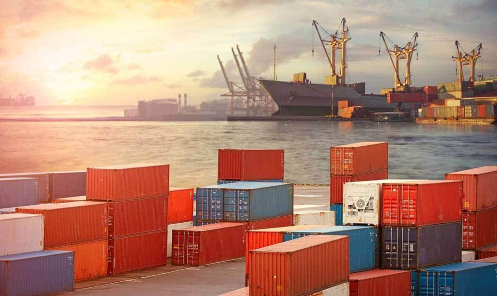 view of containers in a a port terminal with loading cranes in the background.