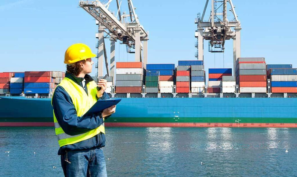 Dock inspector checks for import compliance on incoming shipment from a cargo carrier.
