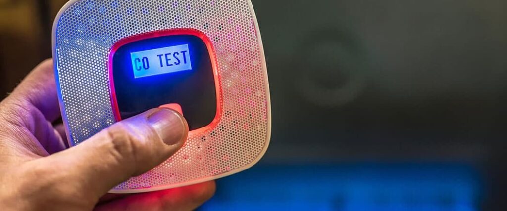 A person holding a hand held air quality sensor with a touch screen