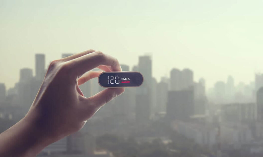 A person holding a air quality sensor