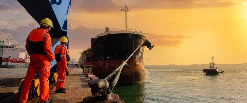 longshoreman slowdown 2023 two dockworkers walking towards a container ship