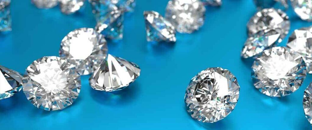 An assortment of princess cut diamonds on a blue table.