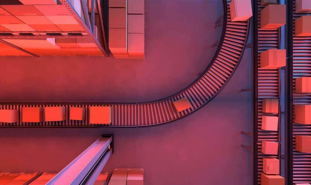 Overhead view of boxes moving along a curving conveyor belt between warehouse racks.