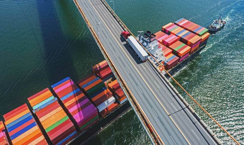 A container ship passing under a bridge