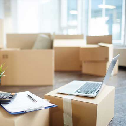 Importing Personal Items - Laptop, calculator & clipboard on top of boxes