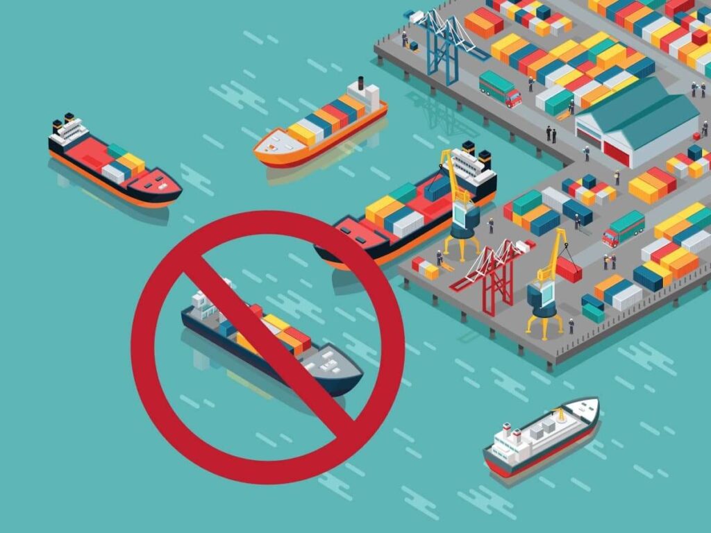 An animated image representing container ships around a port terminal shows a circle with a line through it over a ship, indicating that it can't be received at port.